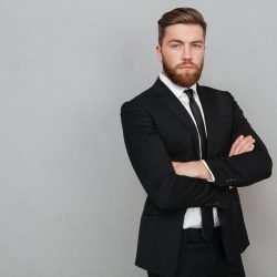 confident-young-businessman-suit-standing-with-arms-folded-scaled.jpg