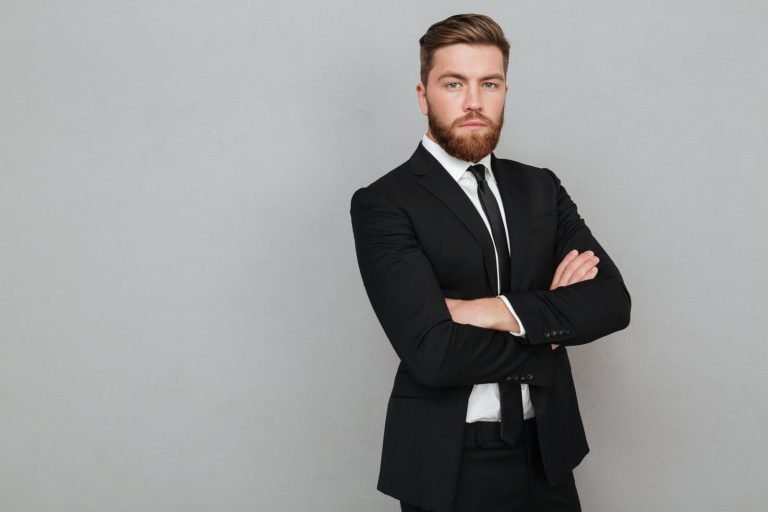 confident-young-businessman-suit-standing-with-arms-folded-scaled.jpg